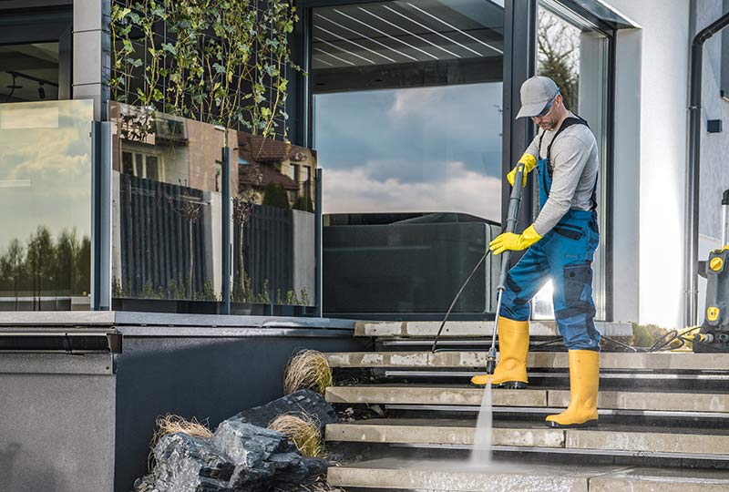 Looking Glass Cleaning Soft Wash Services image. Image of a person power washing a patio.
